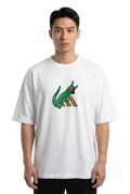 A man wearing a white short-sleeve t-shirt with a green and brown crocodile graphic on the chest, set against a plain white background.