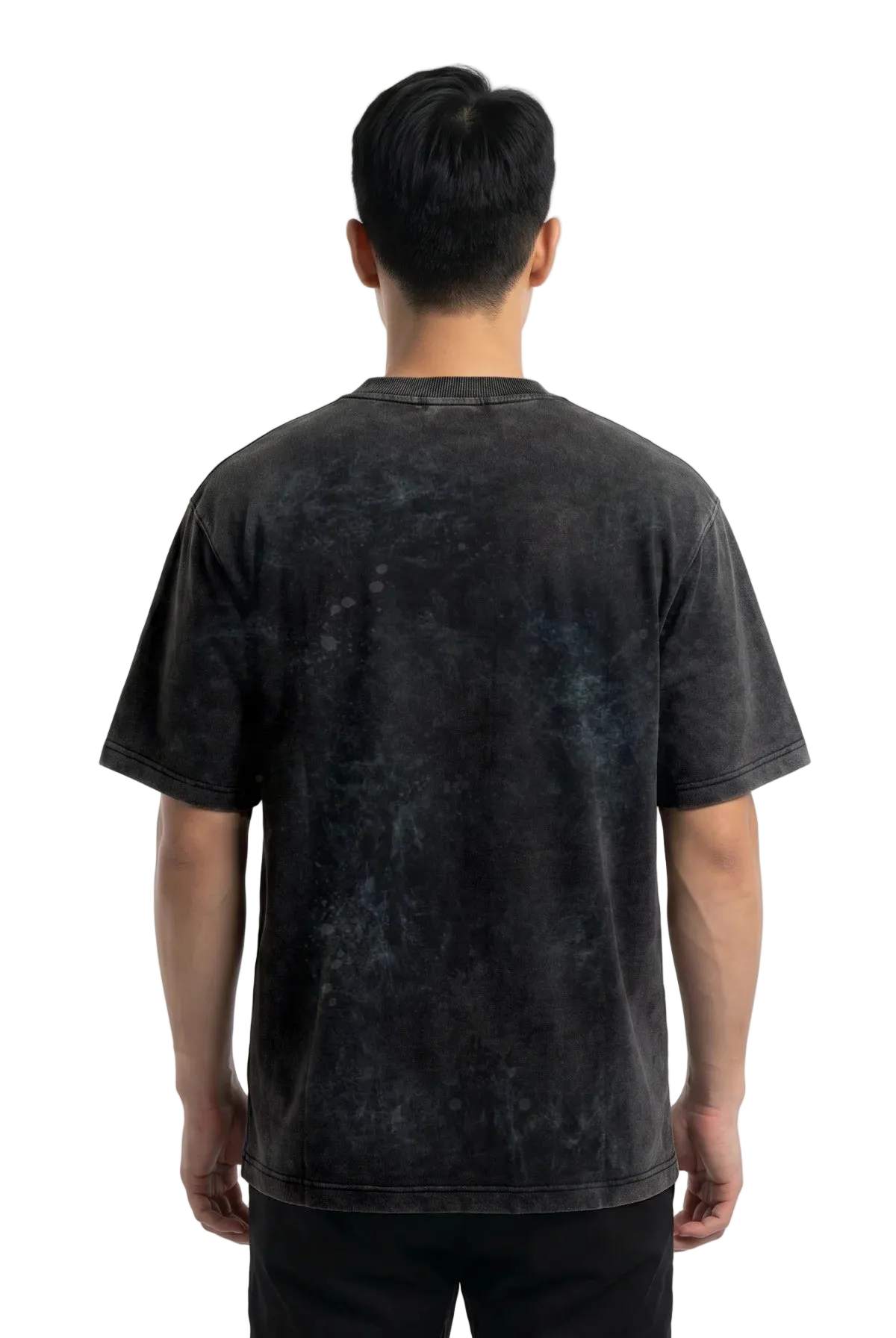 A man viewed from behind wearing a dark charcoal gray mineral-wash t-shirt and black pants, standing against a plain white studio background.