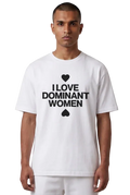 A man wearing a white short-sleeve t-shirt with a black graphic print that reads 'I LOVE DOMINANT WOMEN' with a heart and spade symbol, set against a plain white background.