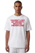 A man wearing a white short-sleeve t-shirt with bold red text on the chest that reads 'I HAVEN'T LOST MY VIRGINITY BECAUSE I NEVER LOSE!'.