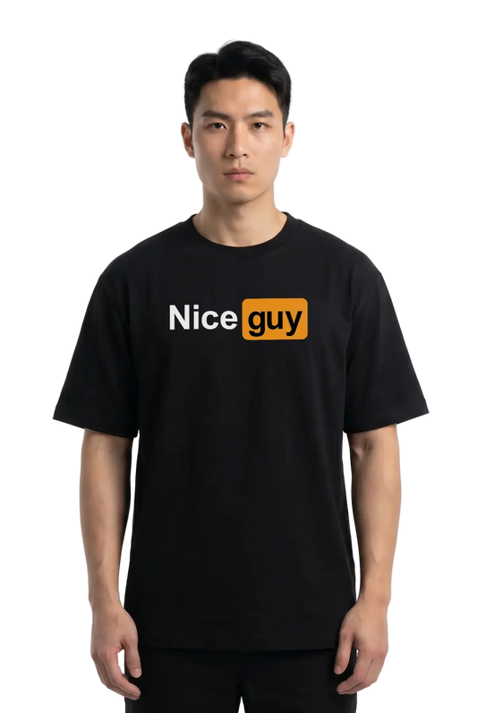 A man wearing a black short-sleeve t-shirt with a graphic on the chest that reads 'Nice guy' in white and orange, set against a plain white studio background.