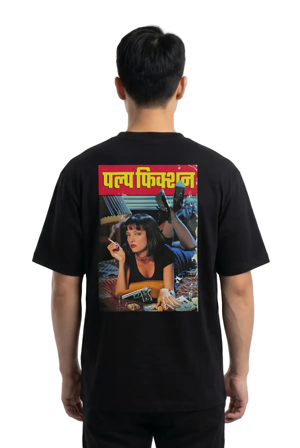 A man viewed from the back wearing a black t-shirt with a large graphic print on the back. The print features the Hindi text 'Pulp Fiction' in yellow on a red banner above a colorful illustration of a woman.