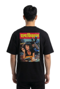 A man viewed from the back wearing a black t-shirt with a large graphic print on the back. The print features the Hindi text 'Pulp Fiction' in yellow on a red banner above a colorful illustration of a woman.