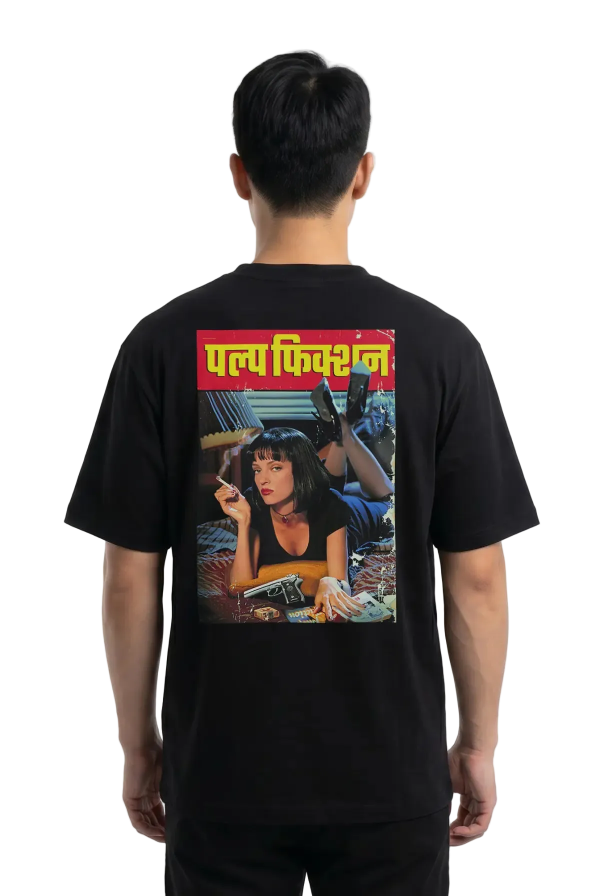 A man viewed from the back wearing a black t-shirt with a large graphic print on the back. The print features the Hindi text 'Pulp Fiction' in yellow on a red banner above a colorful illustration of a woman.