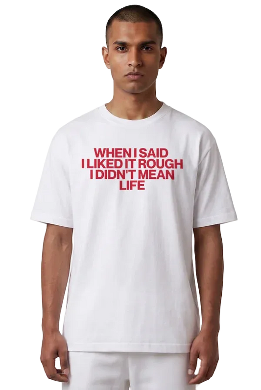 A man wearing a white short-sleeve t-shirt with bold red text on the chest that reads 'WHEN I SAID I LIKED IT ROUGH I DIDN'T MEAN LIFE'.