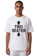 A man wearing a white short-sleeve t-shirt with a bold black graphic print on the front that reads 'TWO SEATER' with arrows pointing up and down, set against a plain white background.