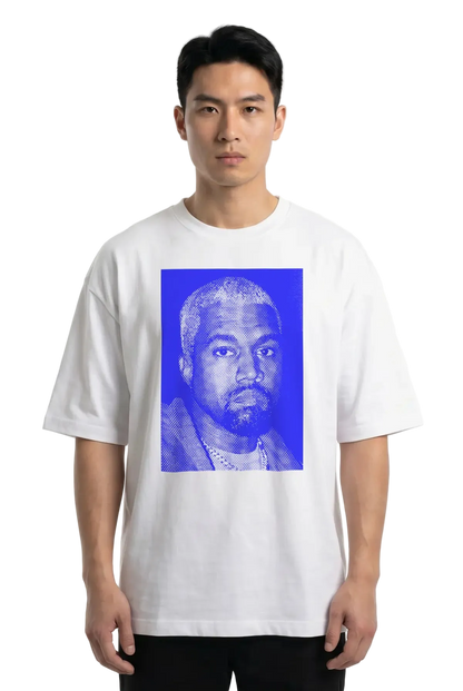 A man wearing a white short-sleeve t-shirt with a large blue graphic print of Kanye West on the front, photographed against a plain white studio background.
